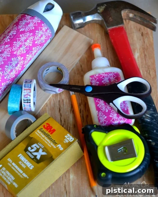 A collection of tools and materials including Washi tape, scissors, wood, and paint for a DIY project.