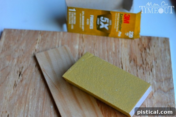 Close-up of a hand sanding the edge of a wooden lattice piece with a 3M SandBlaster Pro Sanding Sponge.