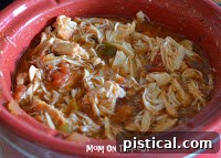 A bowl of slow cooker salsa chicken with a lime wedge