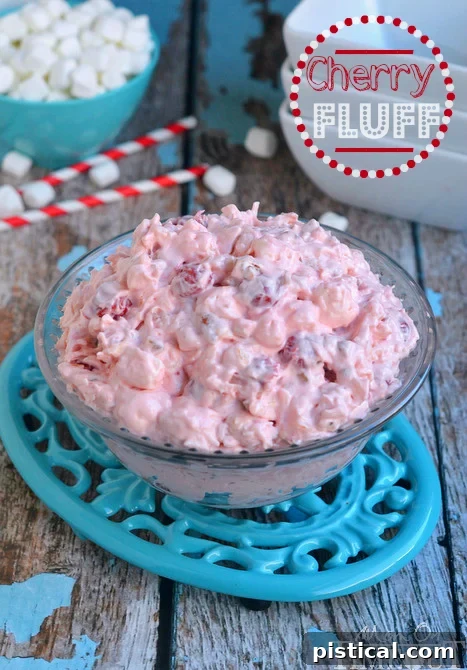 Cherry Fluff dessert salad presented in an elegant clear glass bowl, showcasing its layered texture and vibrant pink color, ready to be served.