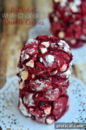 Plate of Red Velvet White Chocolate Crinkle Cookies dusted with powdered sugar, showcasing their festive and chewy texture.