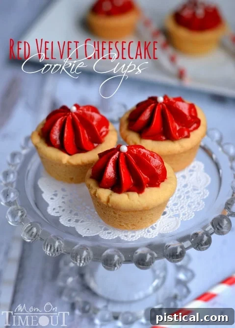 Delicious Red Velvet Cheesecake Cookie Cups - Easy Valentine's Day Dessert | MomOnTimeout.com Close-up of three festive Red Velvet Cheesecake Cookie Cups on a white plate, highlighting their creamy filling and vibrant color, perfect for Valentine's Day celebrations.