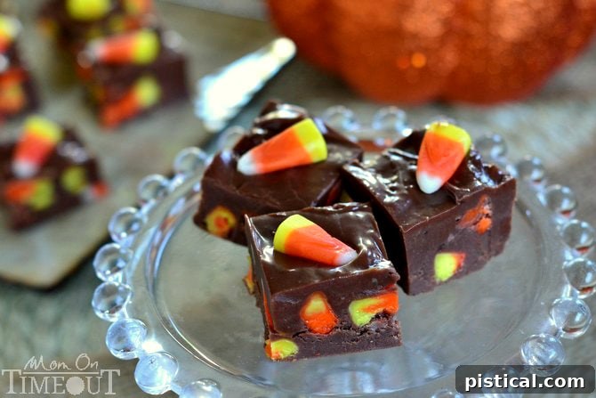 Close-up of freshly made Candy Corn Fudge squares, showing the smooth chocolate fudge texture with scattered candy corn pieces on top and throughout.