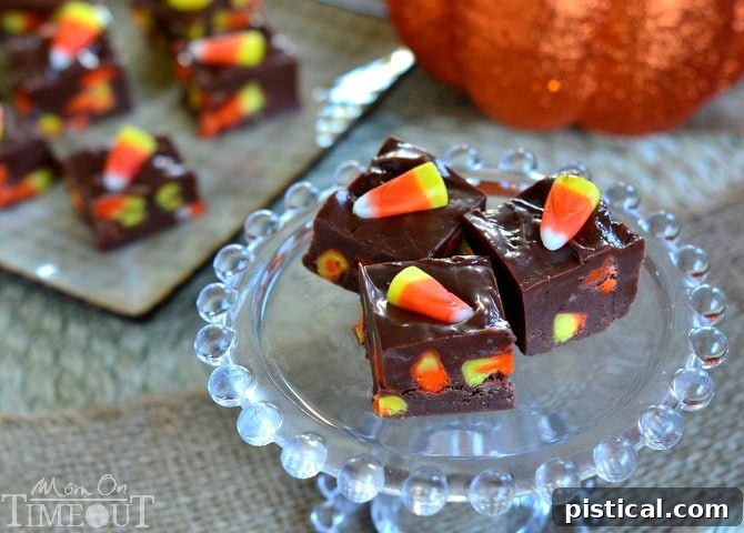 A close-up of a single perfect square of Candy Corn Fudge, displaying its rich chocolate base and the colorful candy corn embedded.