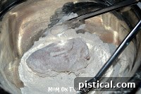 Dredging chicken in flour and paprika mixture