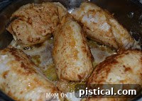 White wine being poured over browned chicken