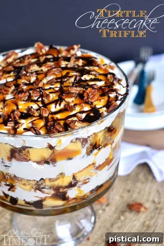 The fully assembled Turtle Cheesecake Trifle, topped with elegant drizzles of caramel and chocolate and a final sprinkle of pecans, ready to be served.