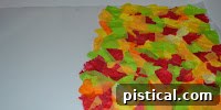 Applying glue to waxed paper and layering small tissue paper pieces.