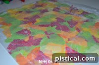 Spreading a thin, even layer of glue on the empty half of the waxed paper.