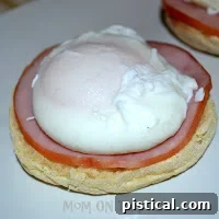 Assembled Eggs Benedict on a white plate, ready to be served.
