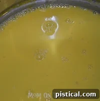 Egg yolks being whisked in a double boiler over simmering water.