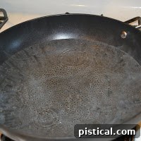 Water simmering in a skillet with a slight ripple, ready for poaching eggs.