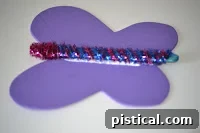 The pipe cleaner and popsicle stick body being glued onto the center of the foam butterfly wings