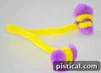 Close-up of pipe cleaner antennae being created with two small pom-poms