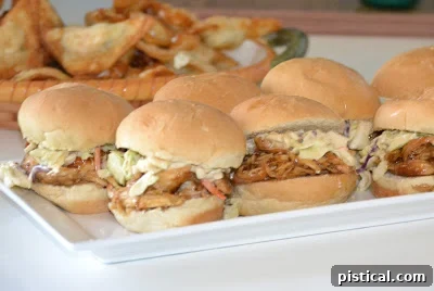 Assorted chicken sliders with slaw, ready for serving at an event.