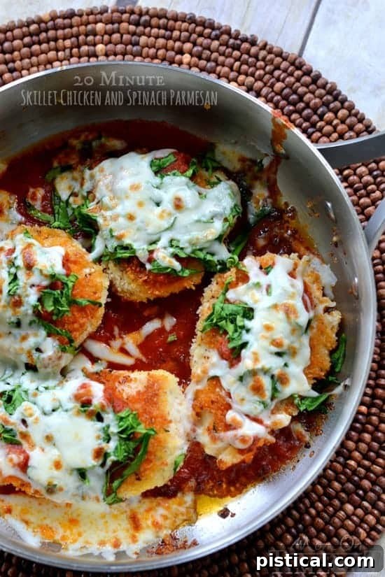 Delicious 20-Minute Skillet Chicken and Spinach Parmesan with melted cheese, fresh spinach, and golden-brown chicken cutlets, served in a skillet. This easy weeknight dinner recipe is a family favorite.