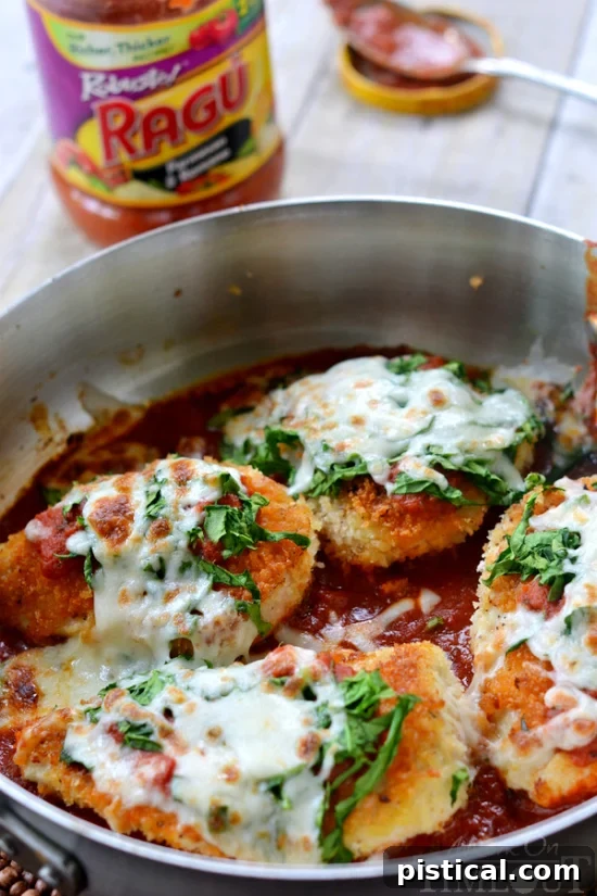 Close-up of golden-brown chicken cutlets cooking in a large skillet, ready to be topped with sauce, spinach, and cheese for a quick Skillet Chicken Parmesan.