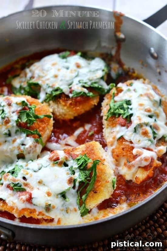 Close-up of cooked Skillet Chicken and Spinach Parmesan, topped with melted mozzarella and fresh spinach, served directly in the skillet.
