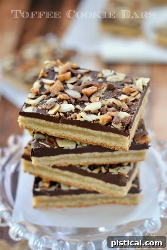 A baking sheet filled with warm Toffee Cookie Bars, still in the pan, with melted chocolate and toppings