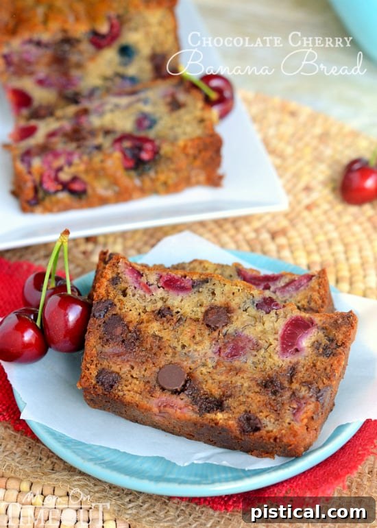 A perfectly sliced loaf of Chocolate Cherry Banana Bread on a wooden cutting board, revealing the moist interior and plentiful mix-ins.