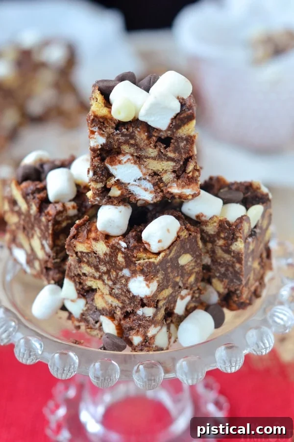 Close-up of Rocky Road S'mores Bars in a clear glass dish, showcasing the layers of chocolate, marshmallows, and graham crackers.