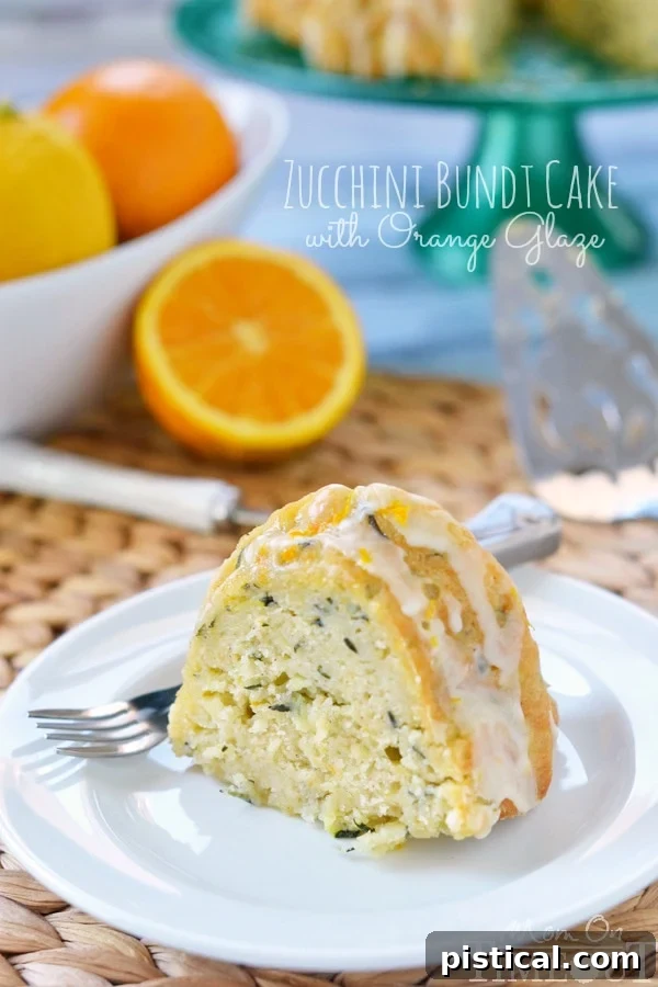 Velvet Zucchini Bundt 4 A generous slice of Zucchini Bundt Cake, showcasing its beautiful texture and the luscious orange glaze drizzled over it.