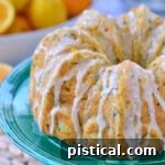 Velvet Zucchini Bundt 7 whole zucchini bundt cake topped with orange glaze and sitting on green cake stand.