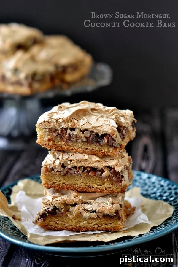 Stunning Brown Sugar Meringue Coconut Cookie Bars, layered with a chewy crust, chocolate chips, coconut, and pecans, topped with fluffy meringue.