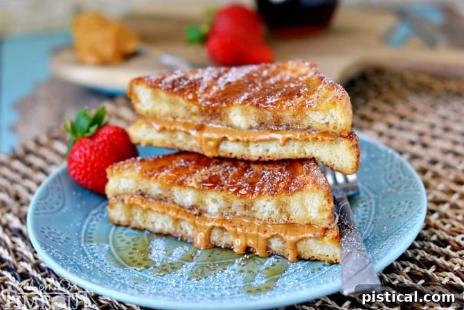 Close-up of Peanut Butter Stuffed French Toast with powdered sugar and berries on the side
