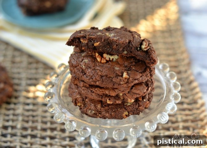 Ultimate Chocolate Toffee Pecan Cookies 3 A close-up of a stack of freshly baked Chocolate Toffee Pecan Cookies, highlighting their chewy, fudgy centers and abundance of chocolate chips and toffee bits.