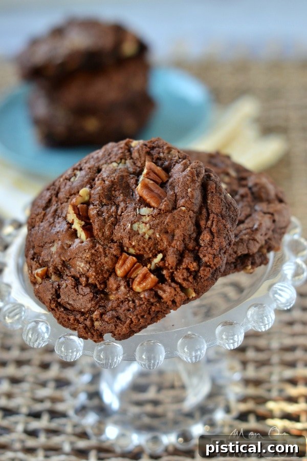 Ultimate Chocolate Toffee Pecan Cookies 7 A beautifully textured Chocolate Toffee Pecan Cookie with melted chocolate and visible toffee bits, ready to be enjoyed.