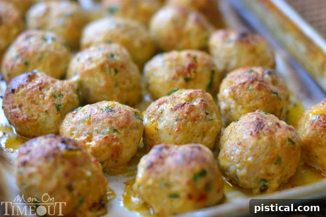 Baked Tuscan chicken meatballs fresh out of the oven, golden brown and perfectly formed.