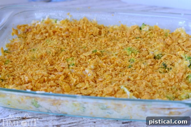 Creamy Chicken Broccoli Rice Casserole baking in a glass dish, bubbling with cheese and topped with a golden brown crust.