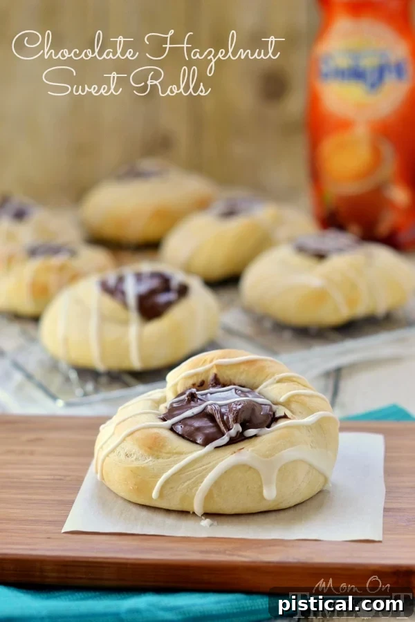 Close-up of golden brown Chocolate Hazelnut Sweet Rolls with a rich chocolate filling, hinting at the irresistible flavor within.