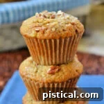 Stacked banana nut muffins with caramel on a blue napkin.