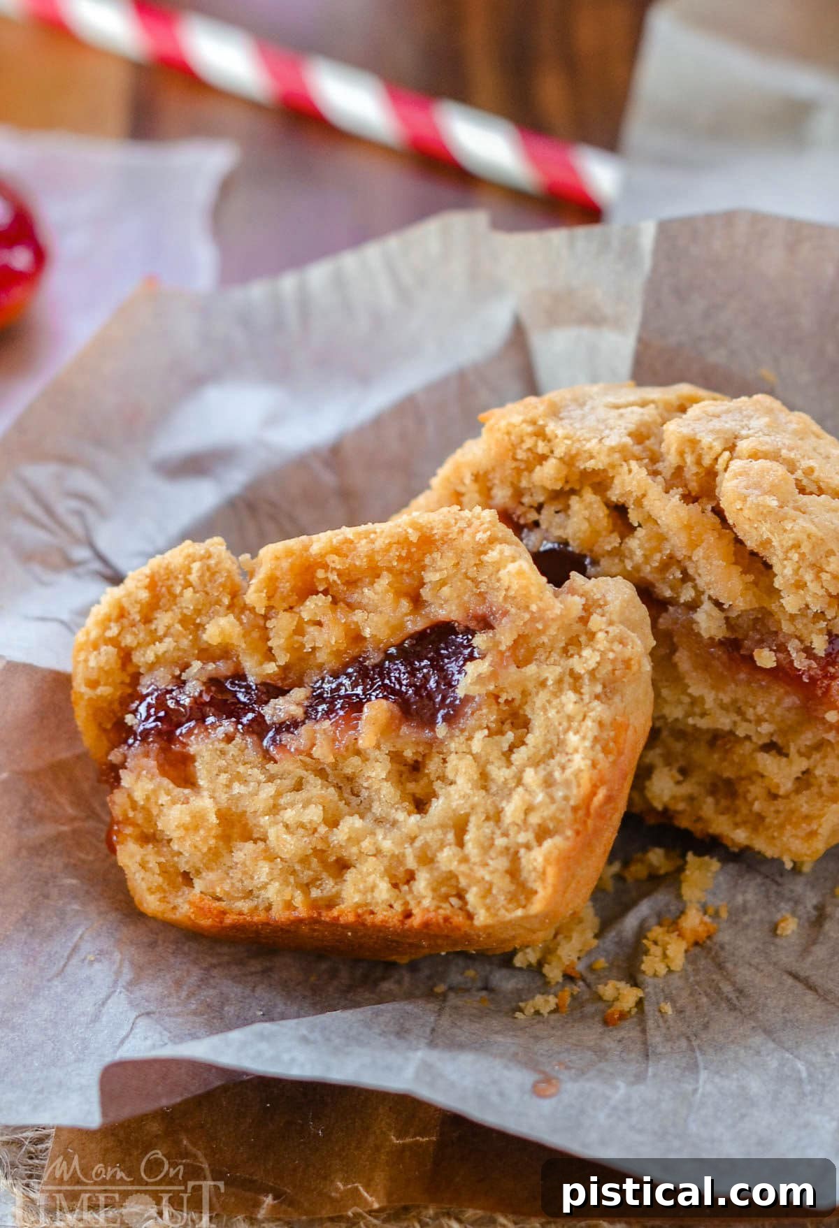 PBJ Muffins 5 One peanut butter and jelly muffins on a piece of parchment. The muffin has been split in half to reveal the jelly center.