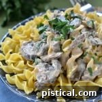 A delicious bowl of Slow Cooker Beef Stroganoff with egg noodles and fresh parsley garnish.