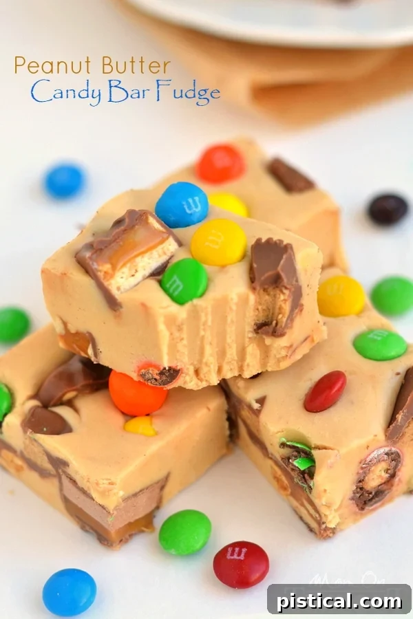 Loaded Peanut Butter Candy Bar Fudge 3 Close-up of a generously sized piece of Peanut Butter Candy Bar Fudge, showcasing the creamy texture and colorful candy pieces embedded within. A perfect homemade dessert or gift idea.