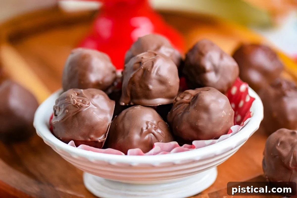 A white ceramic bowl filled with glossy, chocolate-covered Martha Washington candies, perfectly set and ready to be served.