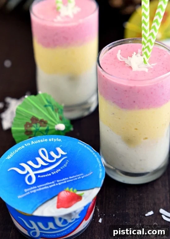 Close-up of a refreshing Tropical Sunrise Smoothie, showcasing its beautiful layers of pineapple, mango, and strawberry.