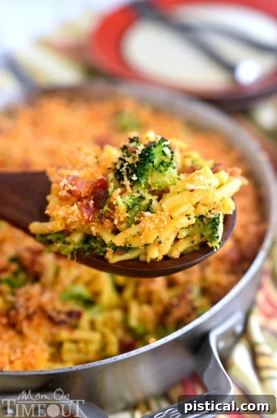 A close-up of Skillet Bacon and Broccoli Macaroni and Cheese, showing generous amounts of broccoli and a crispy topping.