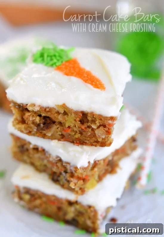 A stack of delicious Carrot Cake Bars, showing their moist texture and generous layer of cream cheese frosting.