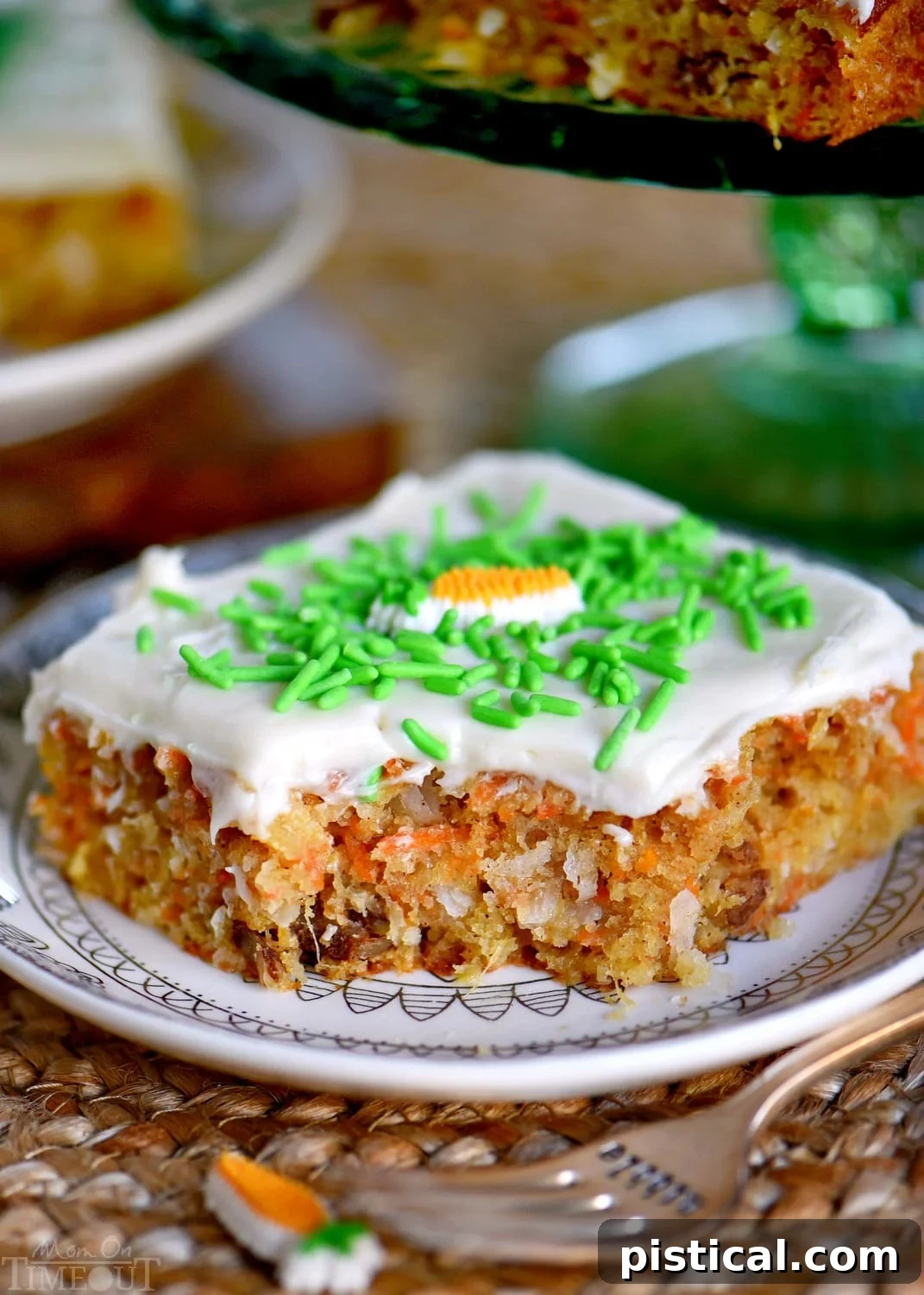 A beautifully sliced Carrot Cake Bar, showcasing the moist cake and thick layer of cream cheese frosting, ready to be enjoyed.