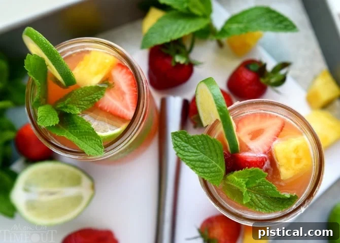 Perfectly cool, sweet, and SO refreshing, this fruit-infused Pineapple Strawberry Mojito cocktail has it all! | MomOnTimeout.com