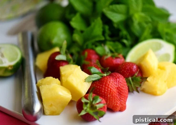 Perfectly cool, sweet, and SO refreshing, this fruit-infused Pineapple Strawberry Mojito cocktail has it all! | MomOnTimeout.com
