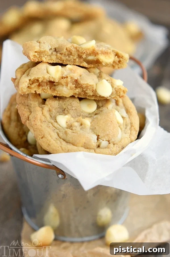 Close-up of a chewy brown butter white chocolate macadamia nut cookie with visible chunks.