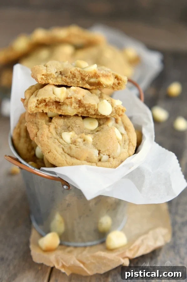 Several brown butter white chocolate macadamia nut cookies on a plate, ready to be enjoyed.
