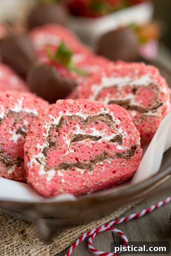 Close-up of vibrant pink Chocolate Covered Strawberry Rice Krispies Treats Pinwheels, showcasing the swirled design and appealing texture. Ideal for any party or picnic, a guaranteed hit for families. A MomOnTimeout.com recipe.