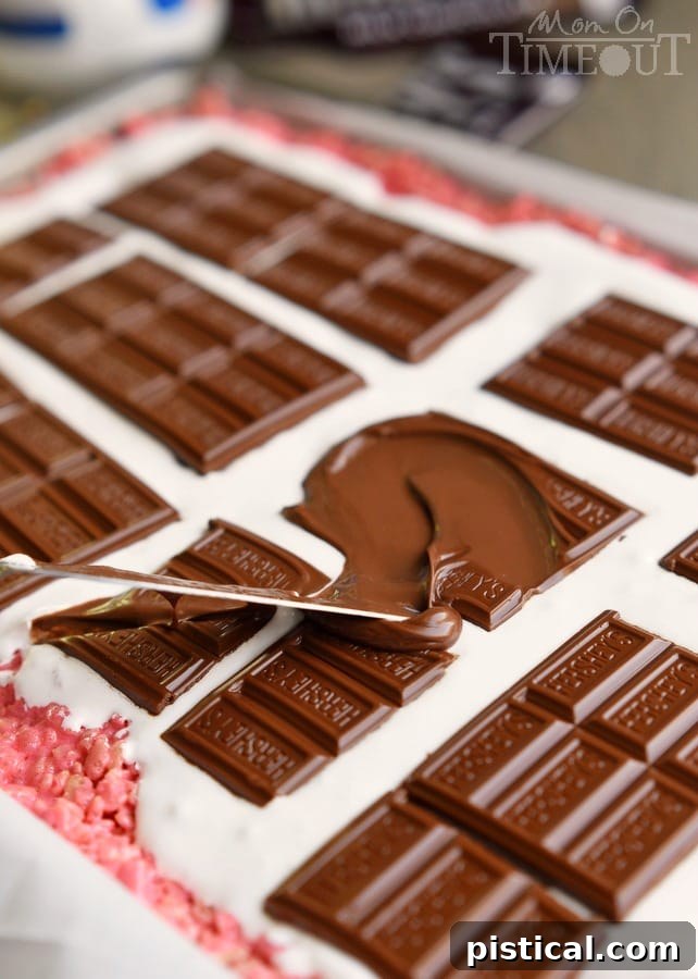 Melted Hershey's chocolate bars spread evenly over a layer of marshmallow creme, ready for rolling into delicious pinwheels.