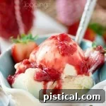A bowl of vanilla ice cream with strawberry topping on top.